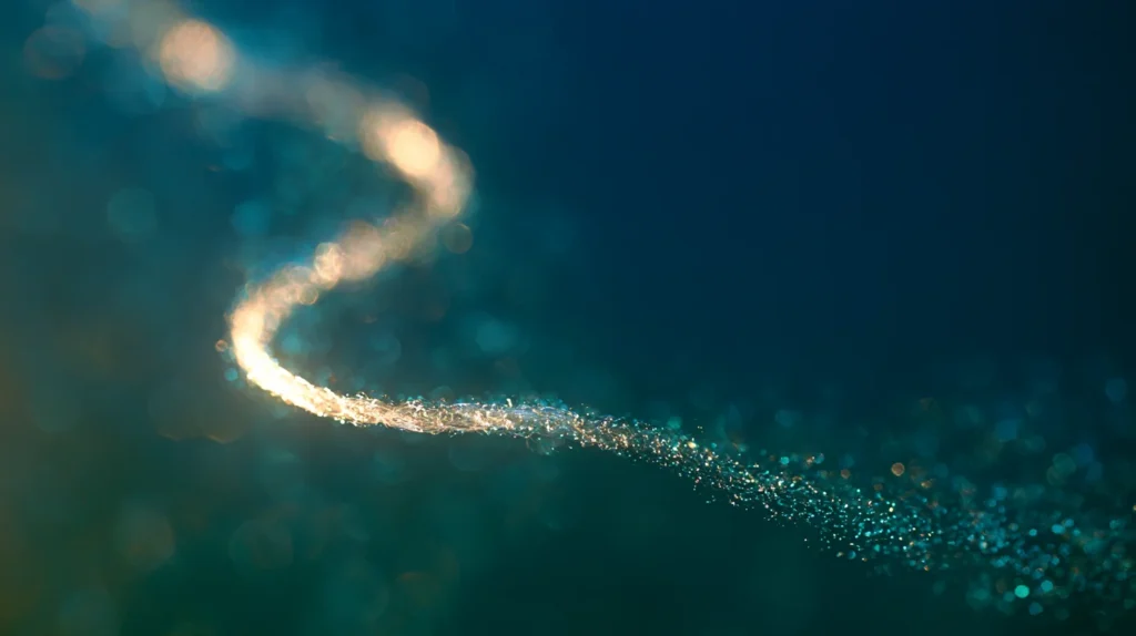 a luminous strand dissolving into particles, macro