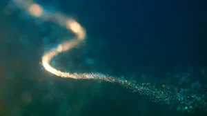 a luminous strand dissolving into particles, macro