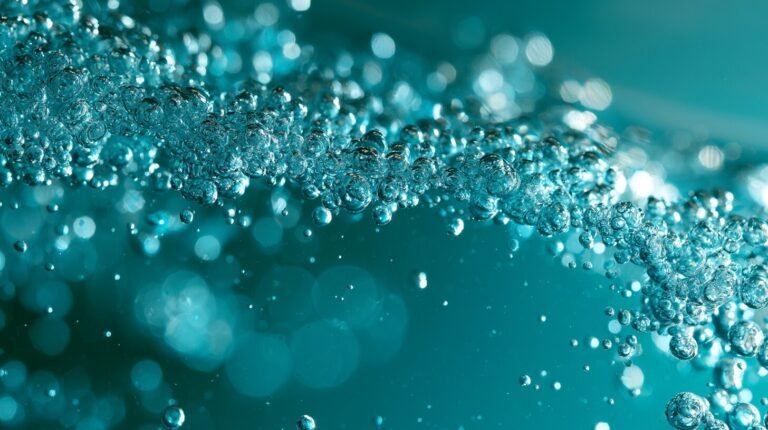 Bubbles scattering unevenly through deep turquoise water