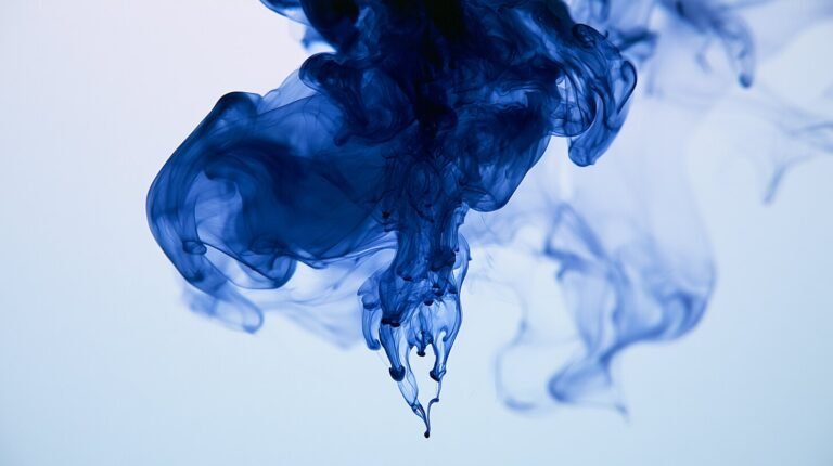 A slow blue plume unfurling downward through still water