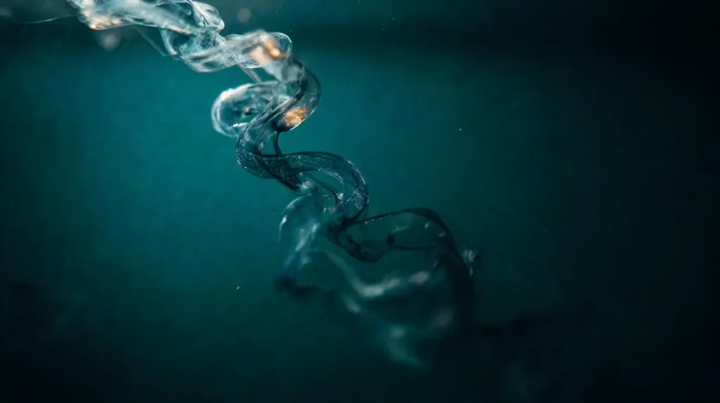 A ribbon of ink curling downward through dark teal water, an abstract image of a rhythm across the day
